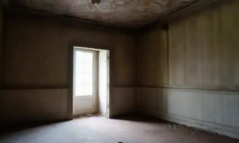 Una habitación tenebrosa y descuidada, llena de sombras y objetos desordenados, evoca una atmósfera de tensión y trauma no resuelto
