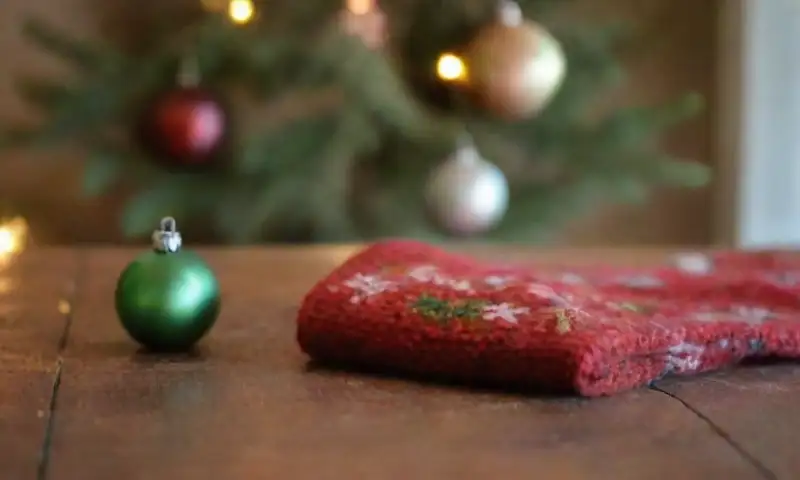 Un acogedor conjunto de calcetos viejos y coloridos, con motivos navideños y decoraciones recicladas, que evoca un encantador espíritu artesanal y ecológico