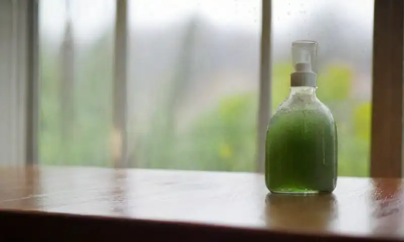 Una ventana de cristal con depósitos minerales y luz natural resalta la limpieza y frescura del entorno