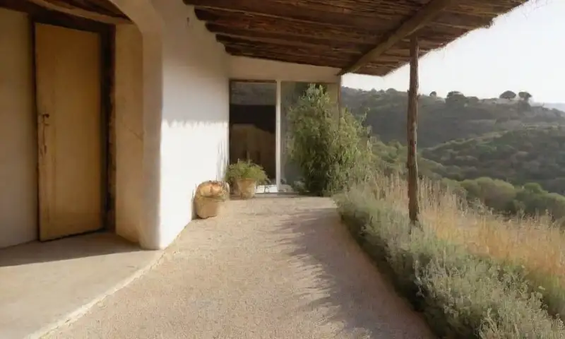 Una casa modesta de encanto rústico, iluminada por la luz dorada de la tarde, rodeada de sal brillante y hierbas vibrantes, con un ambiente sereno y acogedor